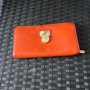 COPY - Michael Kors wallet and the colour is orange with a gold padlock on the …